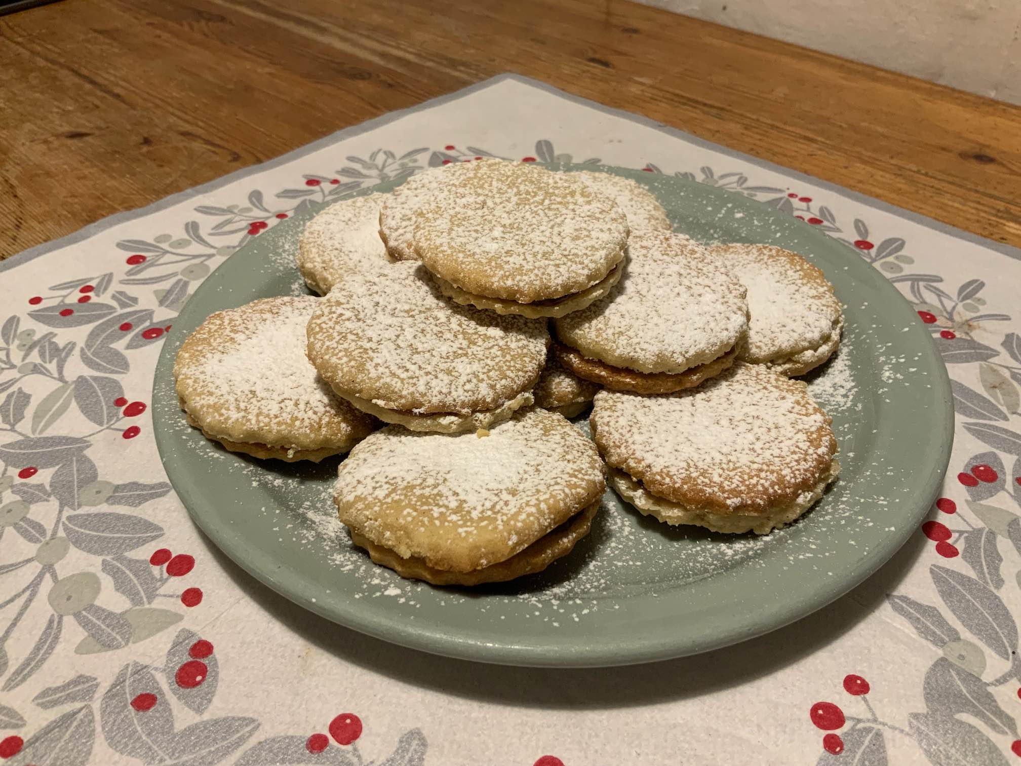 Photo of a plate filled with sugar dusted double-layer cookies.