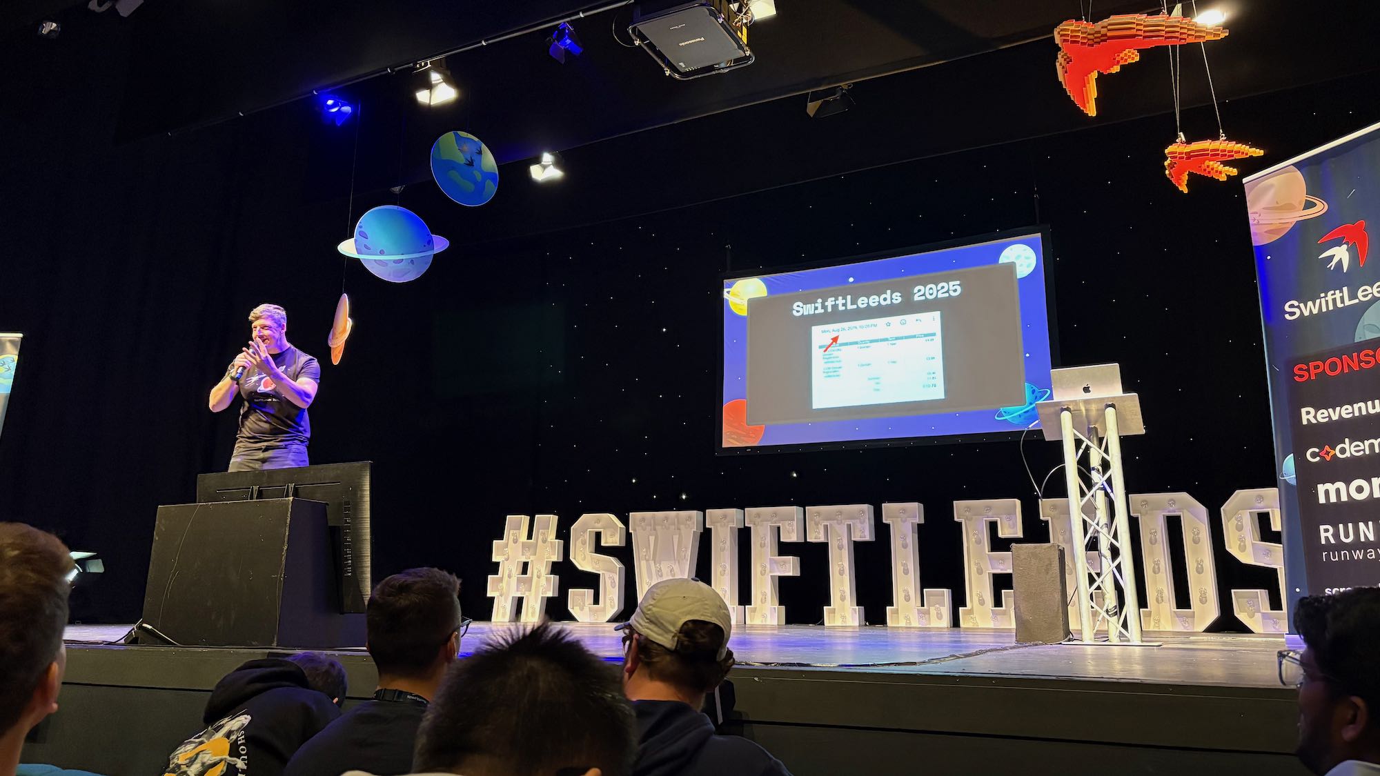 Photo of Adam on stage at the conference.
