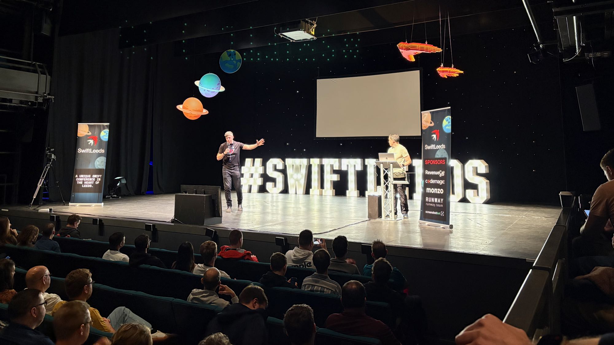 Photo of Adam introducing Chris on stage at the conference.