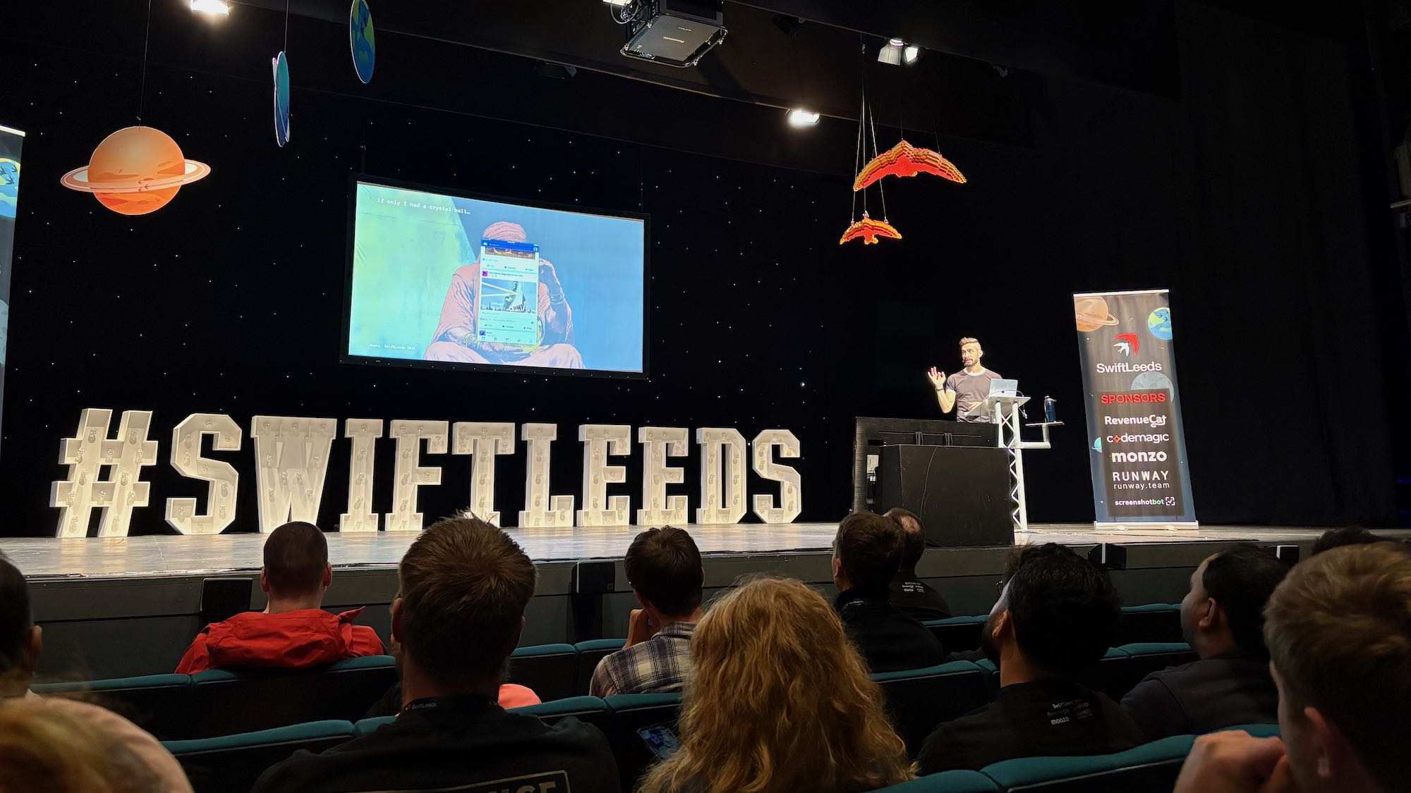 Photo of Sash on stage at the conference.