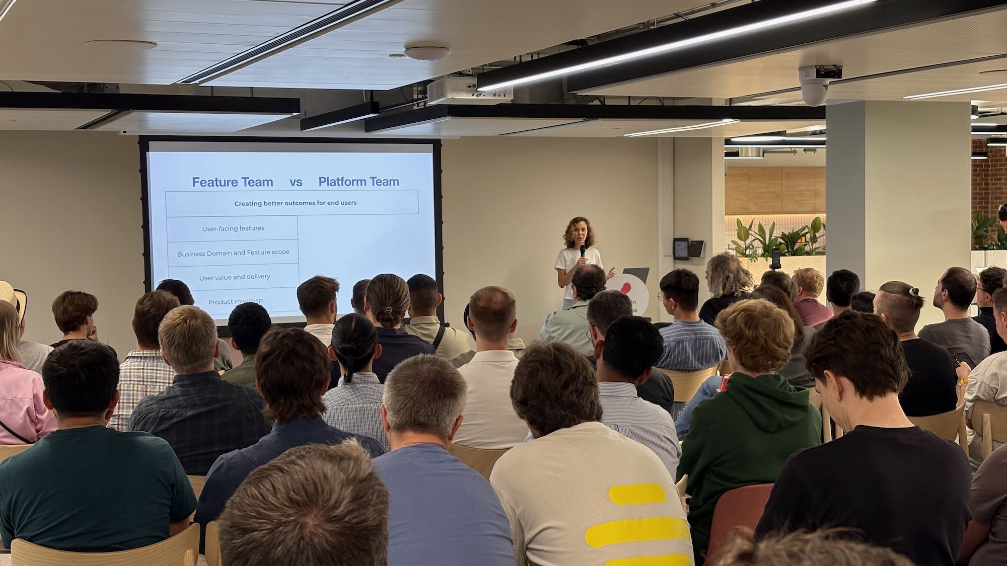 Photo from Anastasia Petrova’s talk with slide showing feature team vs. platform team