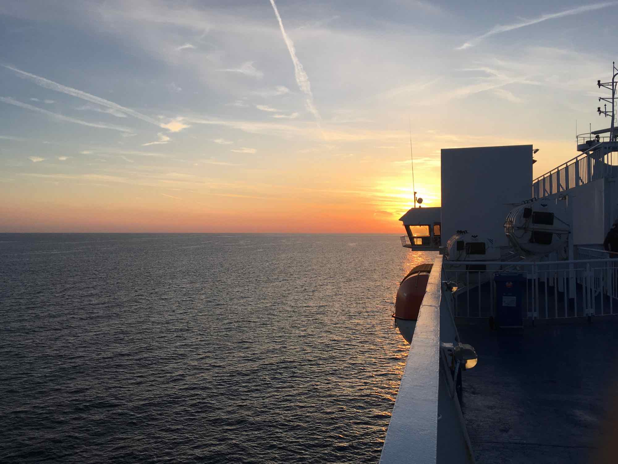 Photo along side of ferry with sunset behind