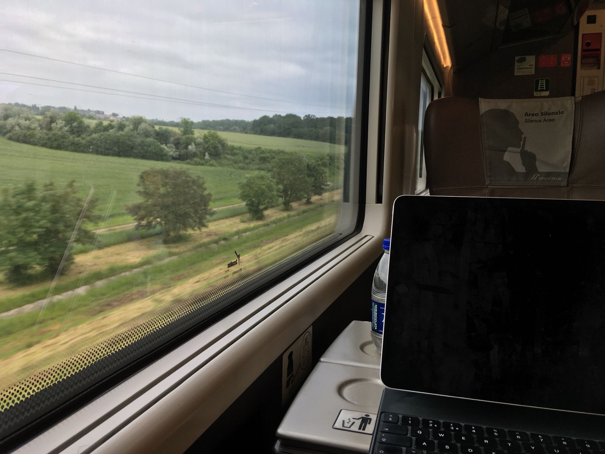 Photo of fields outside train window and iPad Pro in Magic Keyboard