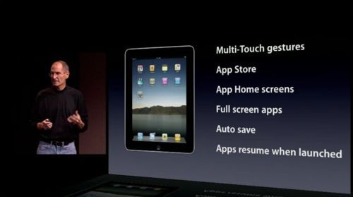 Steve Jobs at the event with the list: Multi-Touch gestures, App Store, App Home screens, Full screen apps, Auto save, Apps resume when launched